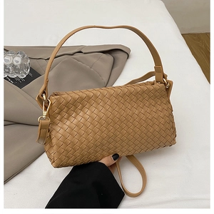 Détail de la texture en cuir tressé caramel sur un sac à main rectangulaire chic