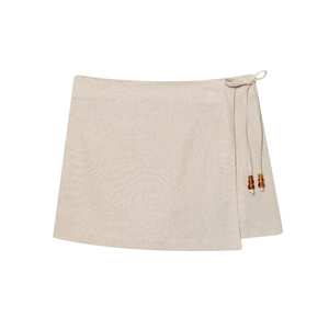 Beige wrap mini skirt in linen fabric with beaded tie-waist detail on white background