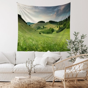 Detail of landscape tapestry showing lush green hills above a white minimalist sofa