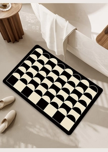 Close-up of a modern black and white geometric bath mat with soft absorbent surface