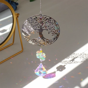Detail of Tree of Life metal suncatcher with crystal prism creating rainbow reflections