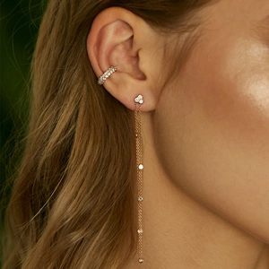 Detailed close-up of gold tassel star earrings with sparkling crystals worn by model