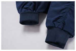 Dettaglio della giacca a vento blu navy con polsini elastici a coste e cuciture fini