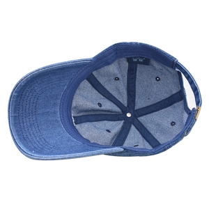Inside view of a washed distressed blue denim baseball cap showing premium lining and label