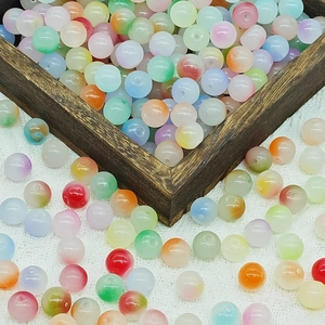 Macro shot of 8mm gradient two-tone glass beads in a wooden tray for DIY jewelry making