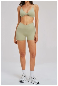 Detail of high-waisted yoga shorts with crossover waistband in light sage green