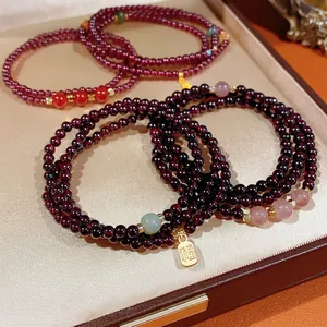 Deep red garnet multi-layer bracelet with gold Fu pendant and semi-precious beads