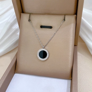 Detailed view of silver necklace with black agate circular pendant and pavé crystals