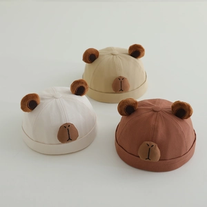 Detailed view of three cotton miki hats for babies in cream khaki and brown colors