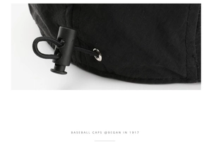 Close-up of black ripstop baseball cap with adjustable drawstring and plastic buckle