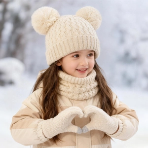 Detail of baby winter knit set with double pom-pom hat, scarf and gloves in snow