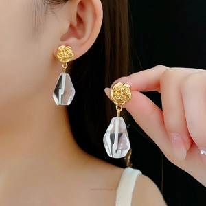Elegant gold flower geometric glass earrings showcased on a model against a black background