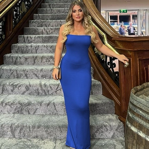 Detail view of a sexy blue backless slim fit maxi dress worn by a model on a staircase