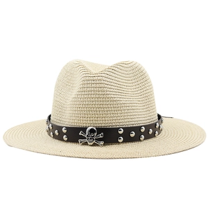 Detail of beige fedora straw hat with black leather band and silver skull metal stud