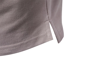 Close-up of side slit detail and double-stitched hem on textured lavender cotton polo shirt