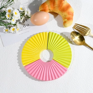 Detailed flat lay of fan-shaped silicone heat insulation pads in yellow, green and pink