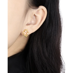 Elegant gold leaf vine earrings with white zircons shown on a model for a realistic fit