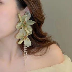 Elegant green fabric flower drop earrings with beads and long tassels on model