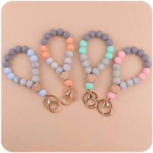 Detail of four colorful silicone beaded keychains with wooden geometric beads and metal clasps