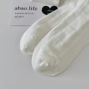 Detail of white ribbed knit socks with fine texture and seamless toe for children