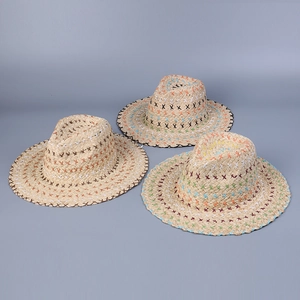 Flat lay of straw sun hats featuring colorful bohemian cross-stitch embroidery details