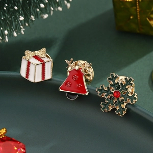 Detail of Christmas enamel brooches featuring gift box, reindeer bell and snowflake designs