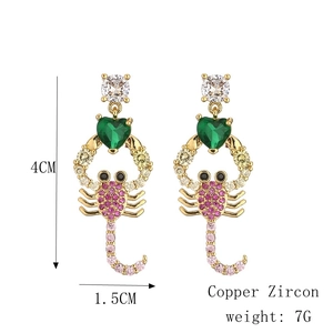 Détails des boucles d'oreilles scorpion dorées avec cœur en zircon vert et cristaux