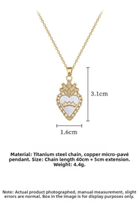 Detailed view of golden heart crown pendant with white enamel and sparkling zircon stones