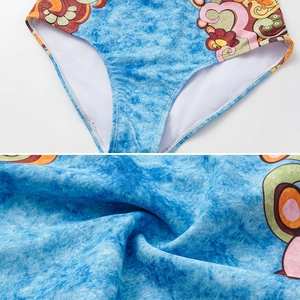 Detailed view of vintage floral print one-piece swimsuit fabric with white lining and stitching