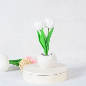 Close-up of white LED tulip night light with ceramic base and realistic texture