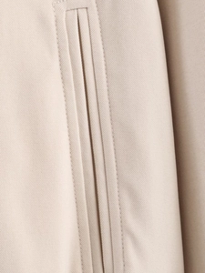 Close-up of beige twill fabric texture and high-quality double stitching on the jacket
