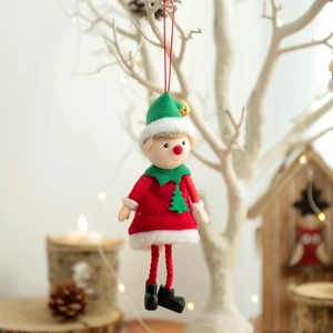 Cute Christmas elf doll ornament with red outfit and green hat hanging on a festive tree