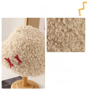 Détail du chapeau bob en peluche beige avec des nœuds rouges à pois et texture douce