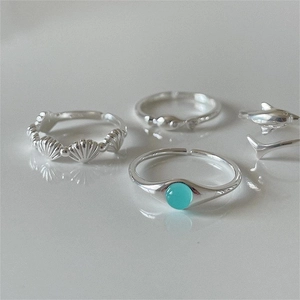 Detail of 925 sterling silver ocean rings set with shell, dolphin and blue crystal