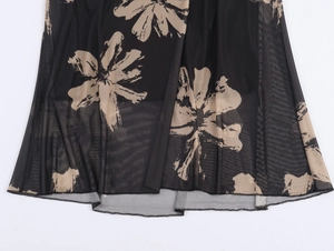Close-up of black mesh fabric hem with beige floral print and fine rolled edge stitching