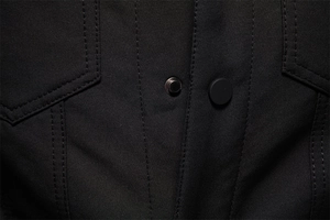 Dettaglio macro della giacca nera in lana d'agnello con trama in twill e doppia cucitura