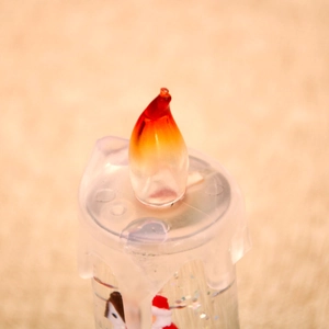 Detailed macro view of the LED flame and Santa Claus inside the Christmas candle lamp