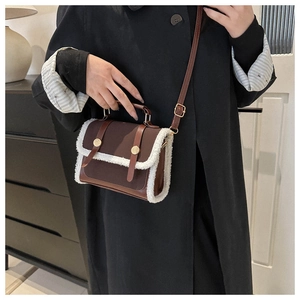 Brown leather crossbody bag with white faux shearling trim and vintage gold hardware