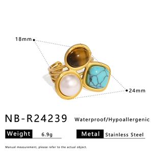Detail of stainless steel ring with tiger eye, turquoise and pearl on white background