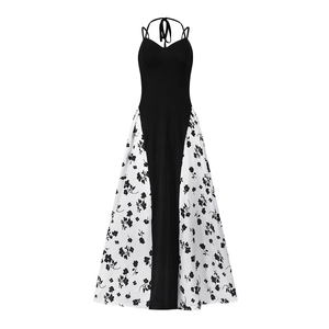 Détail d'une robe longue dos nu avec haut noir et jupe imprimée de fleurs blanches