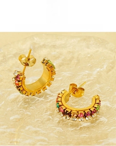 Detail of C-shaped gold-plated earrings with colorful rhinestones and butterfly backs