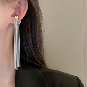 Detail of silver tassel earrings with long metallic chains on model for ear bone style