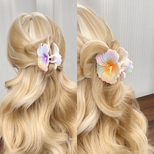 Gradient pearlescent plumeria hair claw clip for women shown on blonde wavy hair