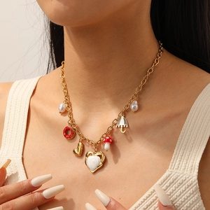 Collana placcata in oro con ciondoli a cuore, ciambella e fungo indossata da una modella