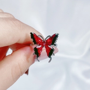 Close-up of red and black enamel butterfly ring with detailed gradient wings