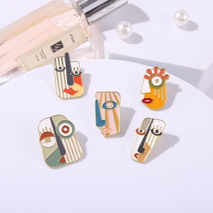 Artistic abstract face enamel brooches set on white display with luxury accessories