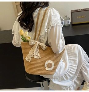 Detailed view of hand-woven straw tote bag with lace bow and daisy floral applique
