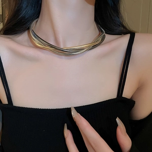 Close-up of chunky gold and silver twisted multilayer chain necklace on neck