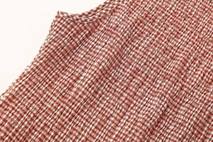 Détail du tissu à carreaux rouges et blancs avec texture smockée pour robe d'été