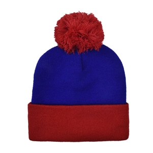 Detail of blue and red knit beanie with a large red pom-pom and ribbed winter texture